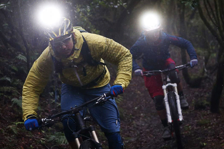 Mountain bike riders wearing headlamps at night