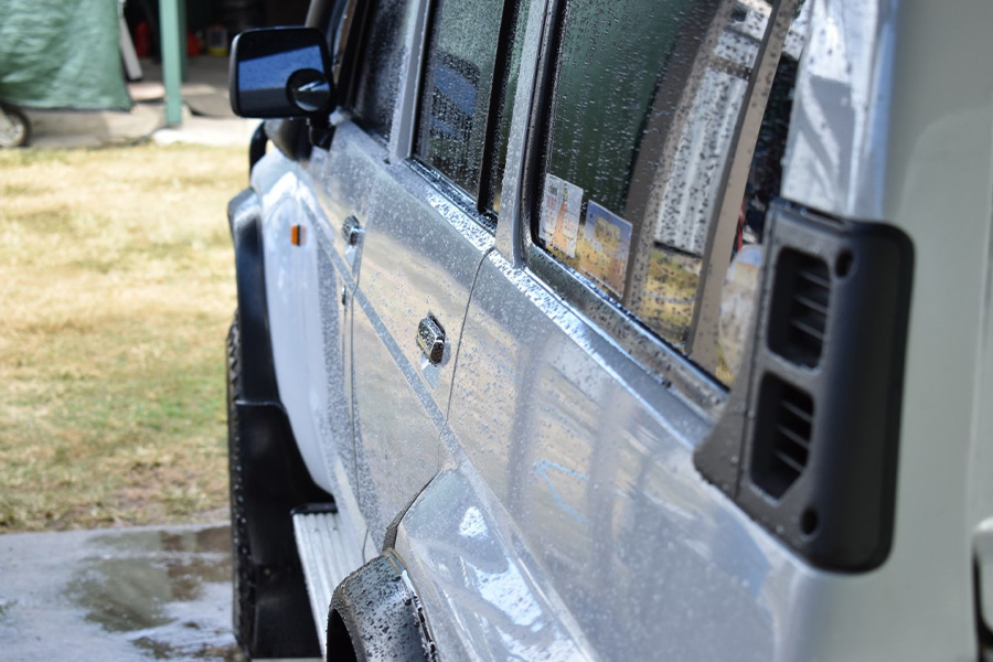 A 4WD coated in beads of water, indicating a fresh wash.