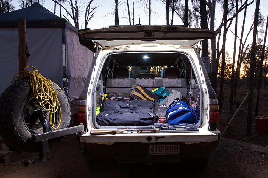 The back of a 4WD displaying an electrical set up with bags and cords. 