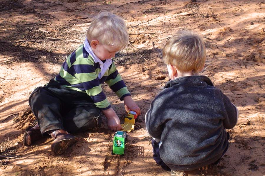 Kids having fun playing with toys in the dirt