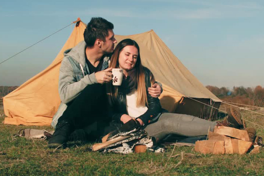 Sad couple sitting in front of tent