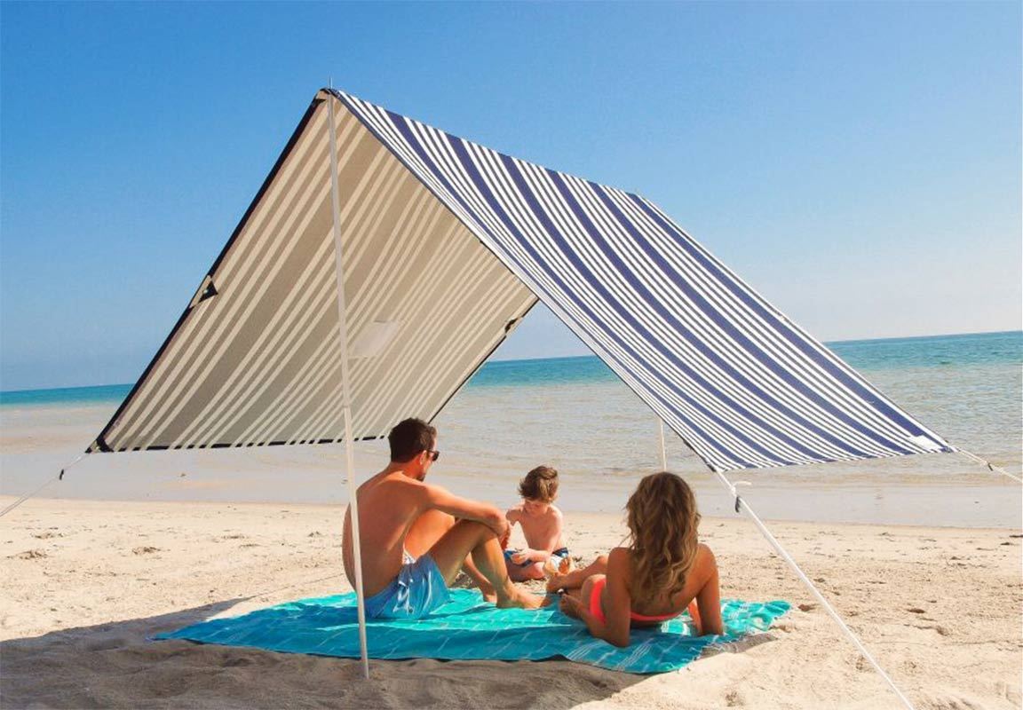 Family laying under beach shelter