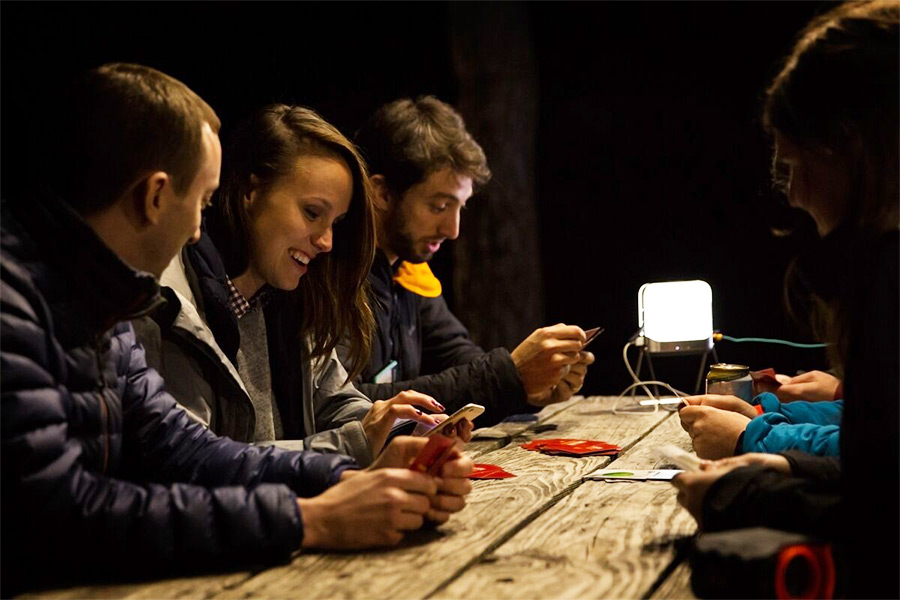 People using their phone at night by a table