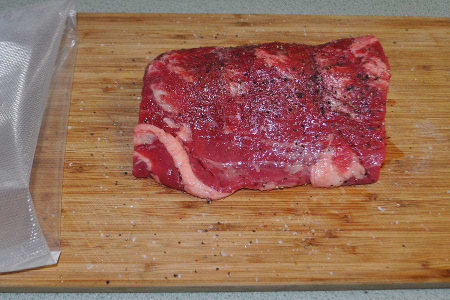Apply salt and pepper before vacuum sealing a fillet of beef