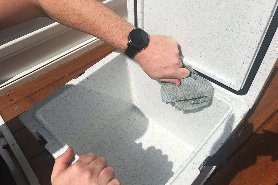 Cleaning an Icebox outside with a cloth