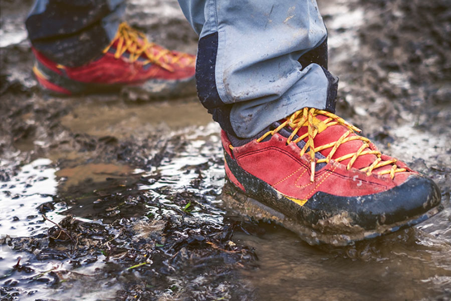 Man walking through mud in hiking boots