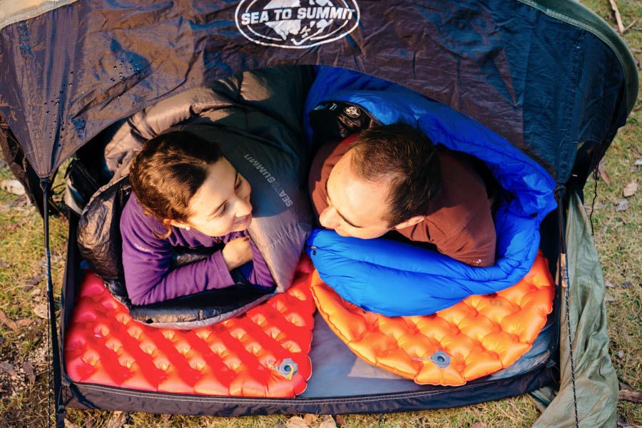 Couple laying on different sized Sea to Summit hiking mats