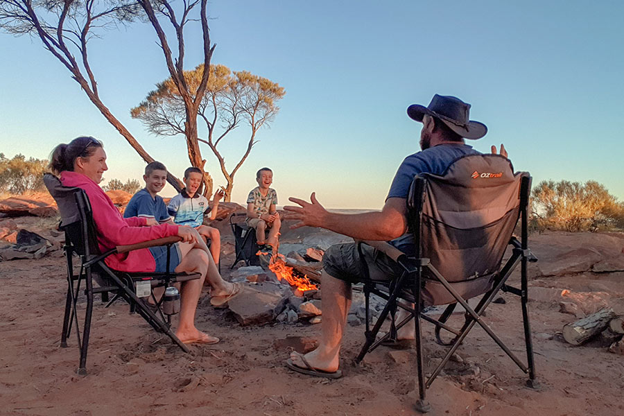 A family sitting around the campfire laughing