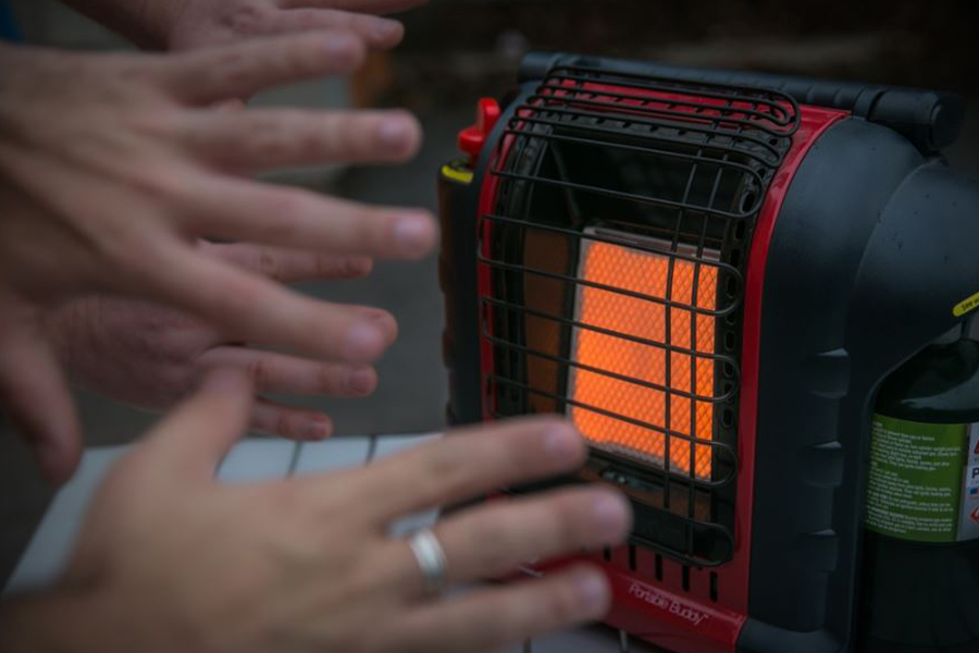 Hands warmed by a gas heater. 