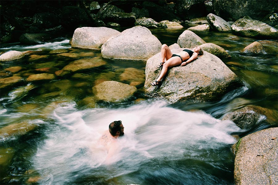 Couple swimming in flowing creek