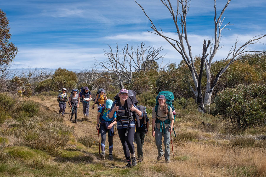 A group of teenage hikers wearing packs.