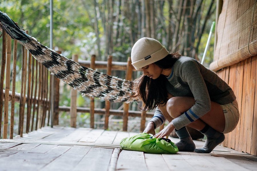 A teenage girl using a Scrubba Washbag out on a cabin deck. 