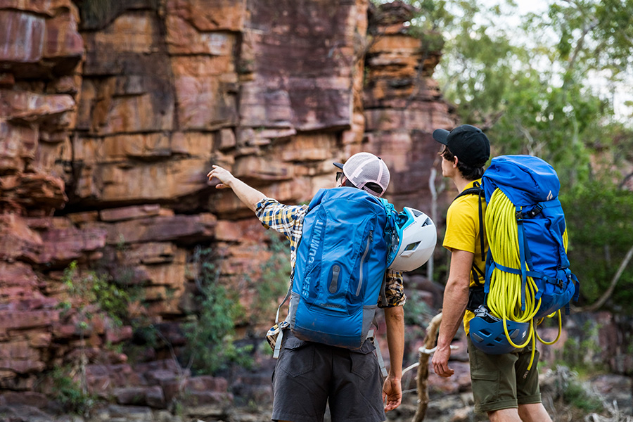 Two campers wearing packs, pointing ahead.