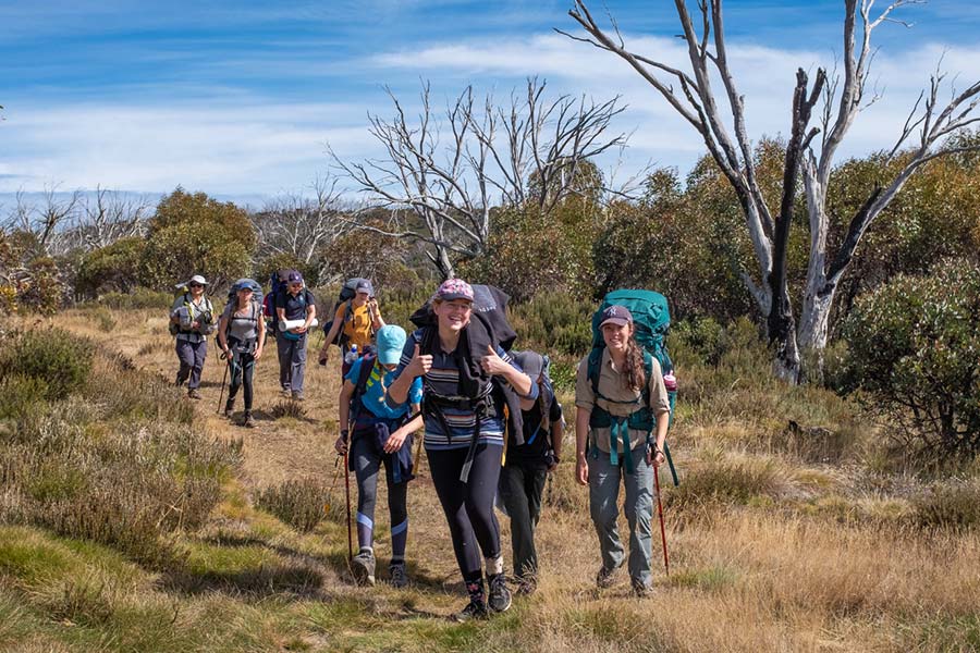 Teenagers hiking with rucksacks in the Australian outback