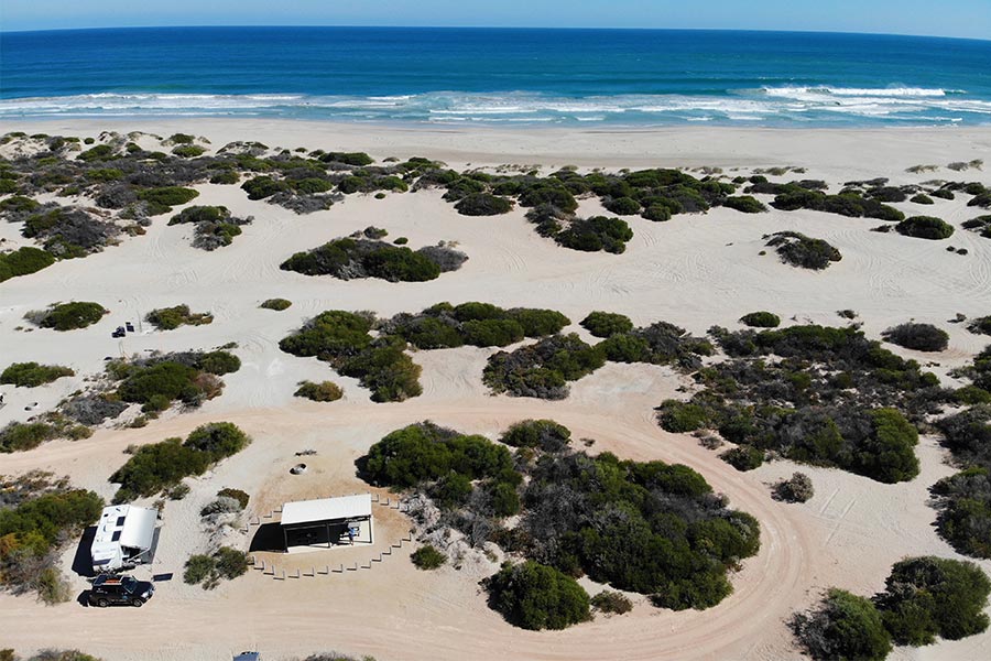 Caravan setup on sand near the ocean
