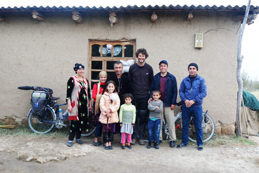 Couple posing for a photo with a family in front of a house