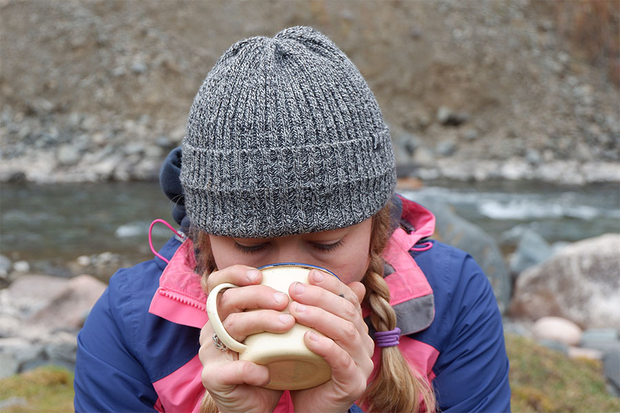 Woman drinking from a mug outdoors