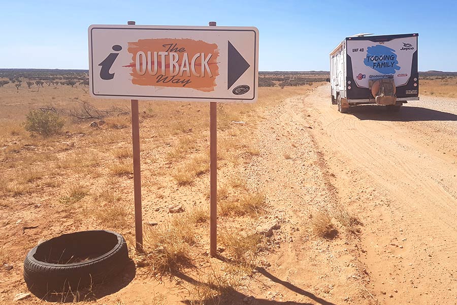 Caravan and 4WD driving in the direction towards The Outback Way