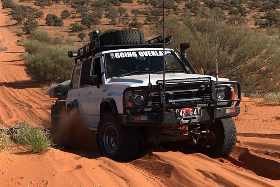 Vehicle driving up a sandy hill road in the Simpson Desert