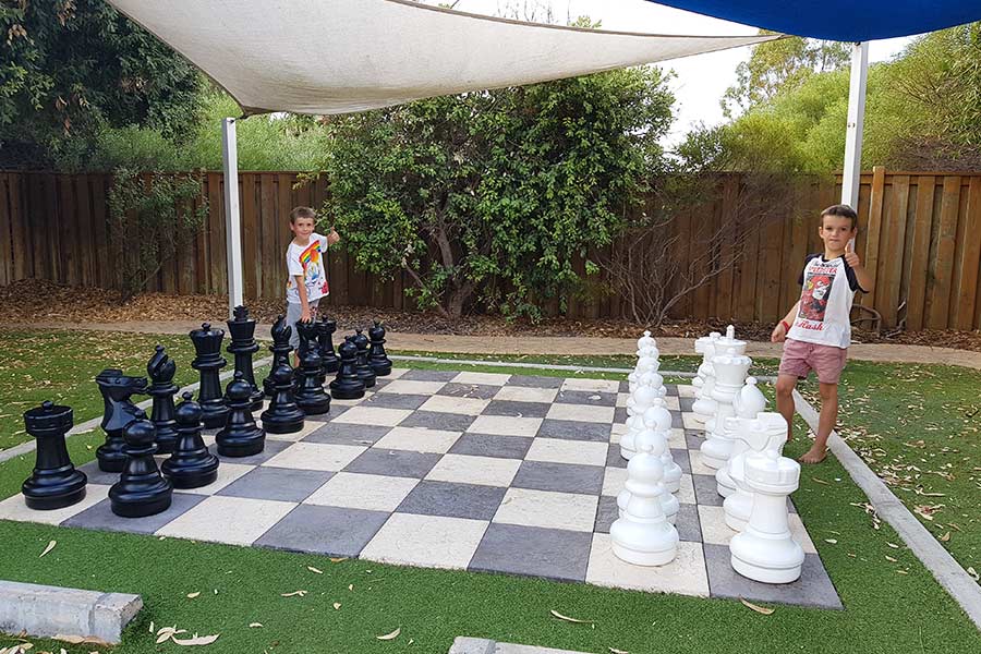 Two boys playing giant chess outdoors