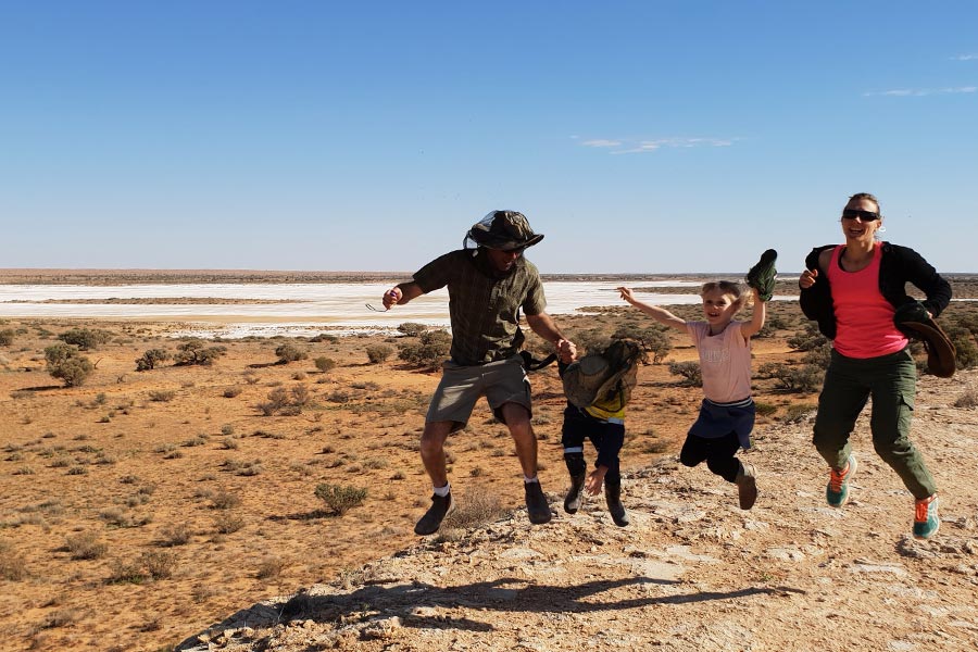 Family jumping in the air in the Simpson Desert