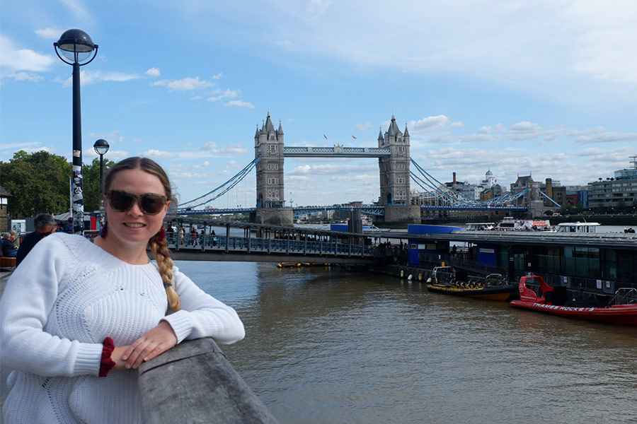 Woman posing for photo next to Tower Bridge in London, England