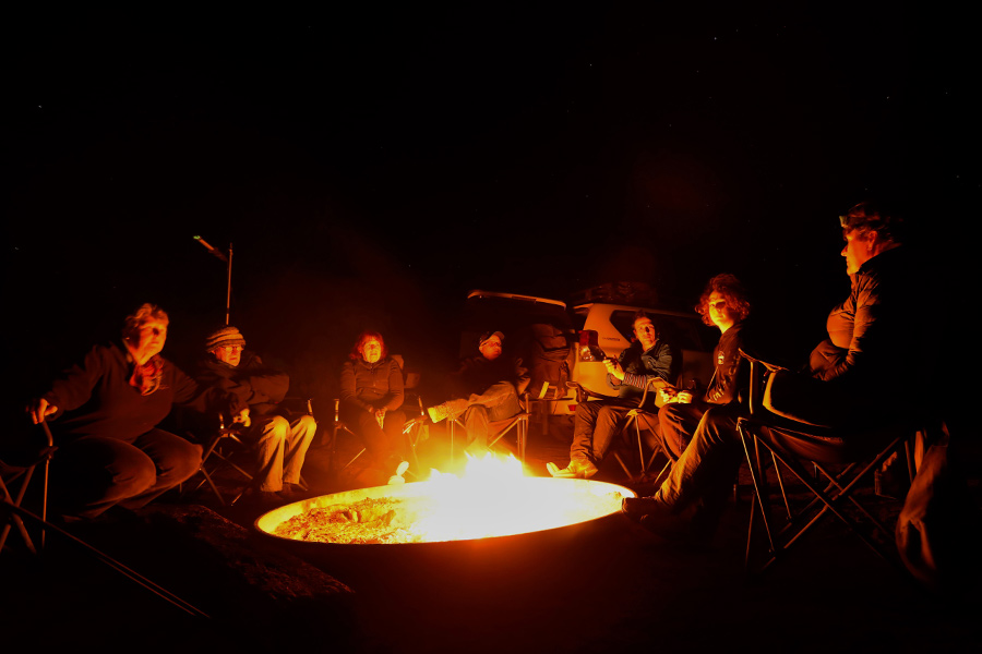 People sitting around a firepit at night