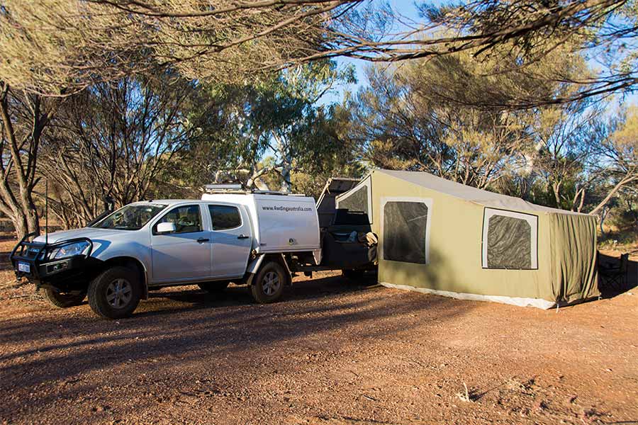 Large camper trailer setup next to a 4wd in the outback