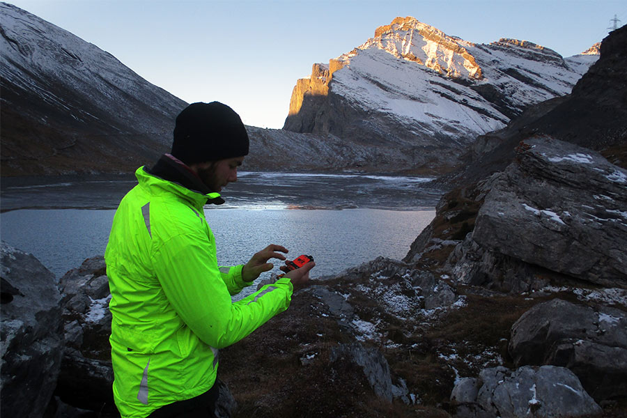 Man using a SPOT satellite messenger device in the moutains
