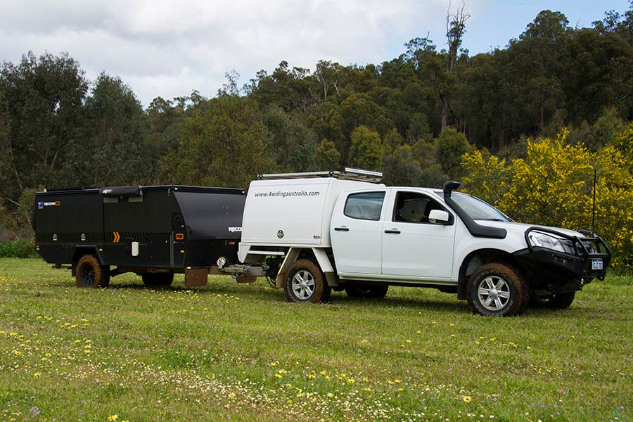 A 4wd towing a triler on green grass