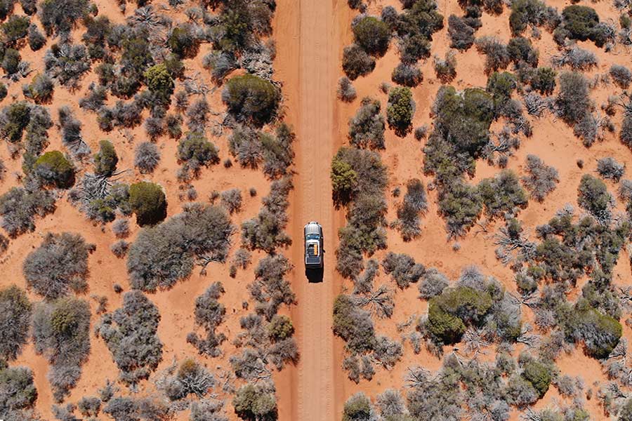 Bird's eye view of 4wd driving along a dirt road in rural Australia