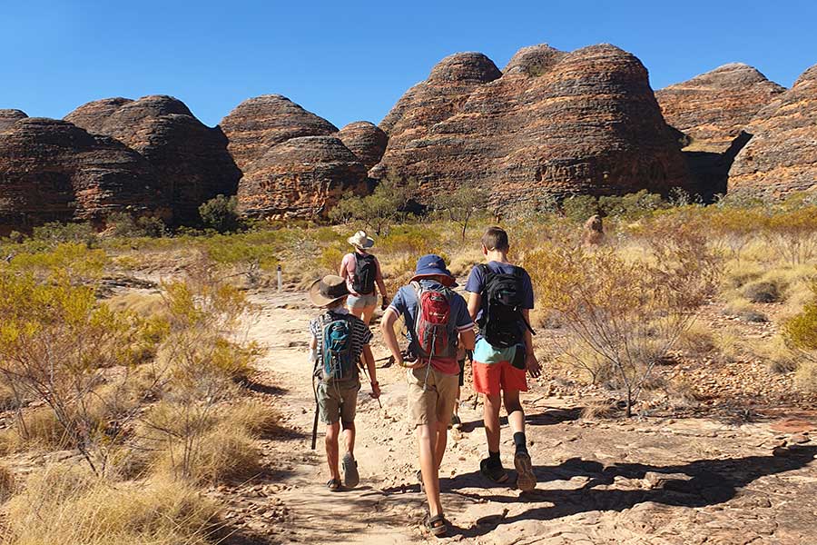 Mother with her sons hiking with backpacks in outback Australia