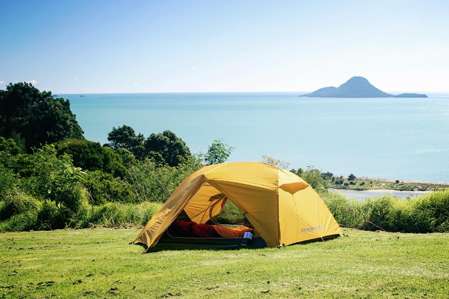 Zempire Zeus tent set up on grass near the ocean
