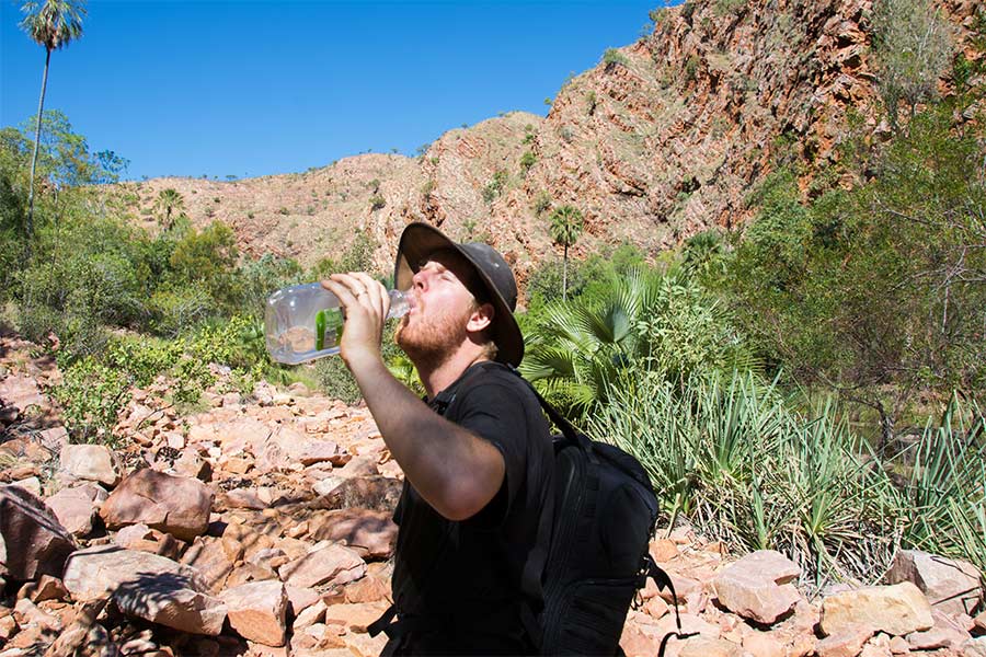 Man drinking water from bottle while hiking in the Kimberley