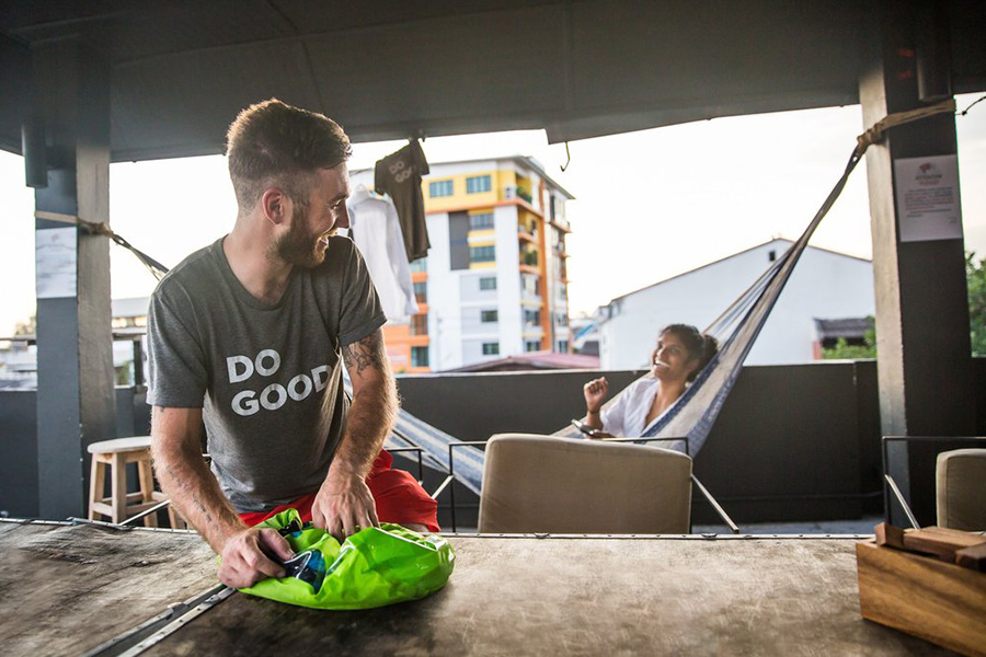 A man is laughing while using a Scrubba Washbag. 