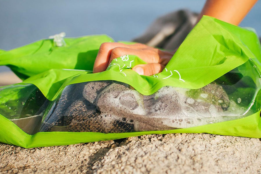 A close-up shot of a hand on a Scrubba Washbag.