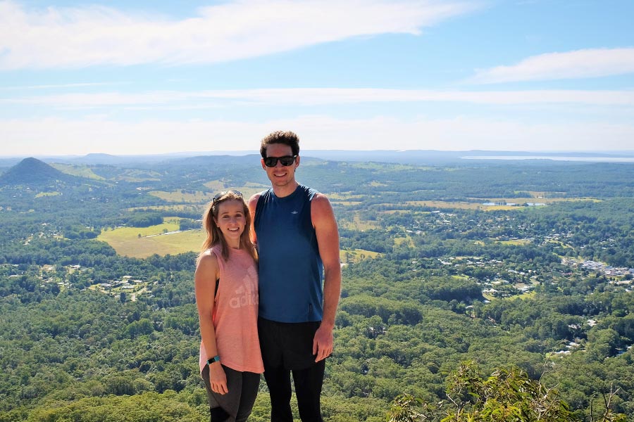 A couple pose for a photo at a lookout