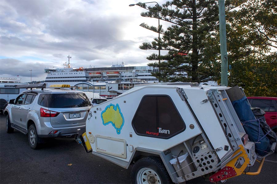 A 4wd towing a Tvan waits at the dock ready to board a ferry.