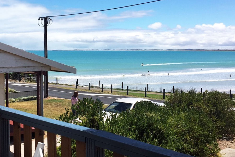 A coastal view from the balcony of an esplanade beach shack.