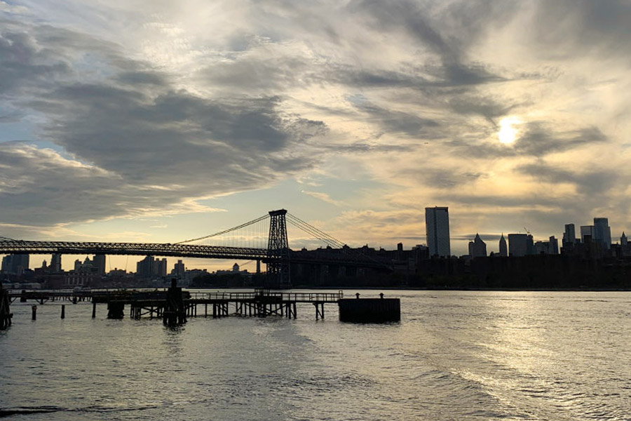 An overcast sunset view overlooking East River and Brooklyn Bridge.