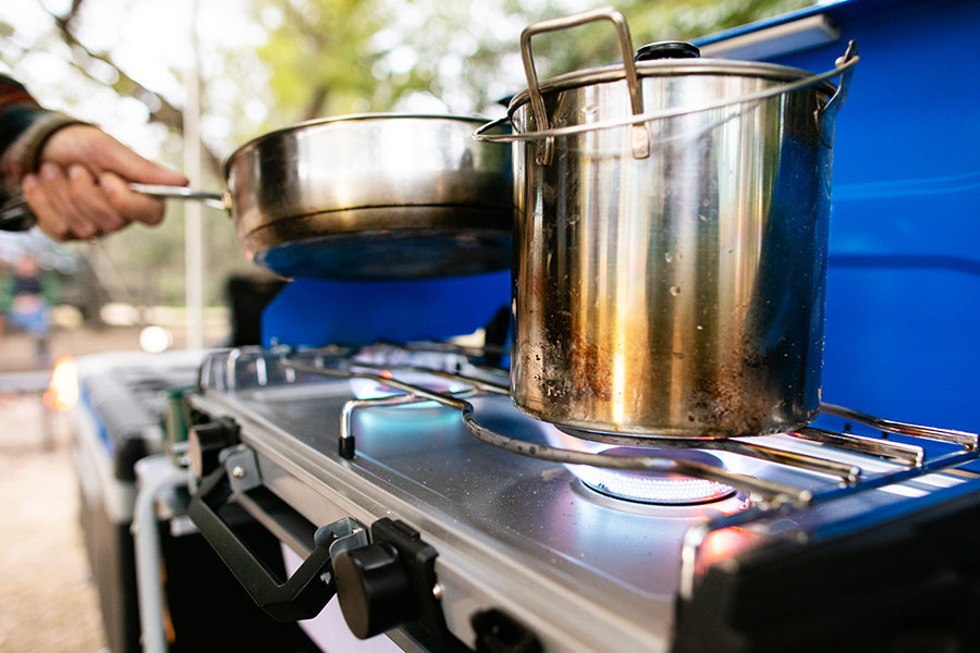 Close up of a big aluminium pot on a camp stove. 