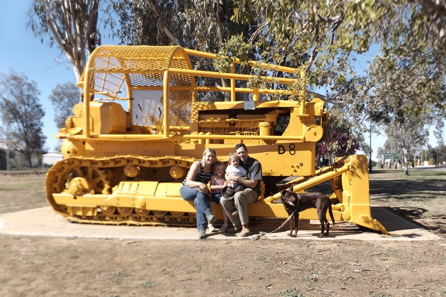 Family posing next to industrial machine in Ilfracombe.