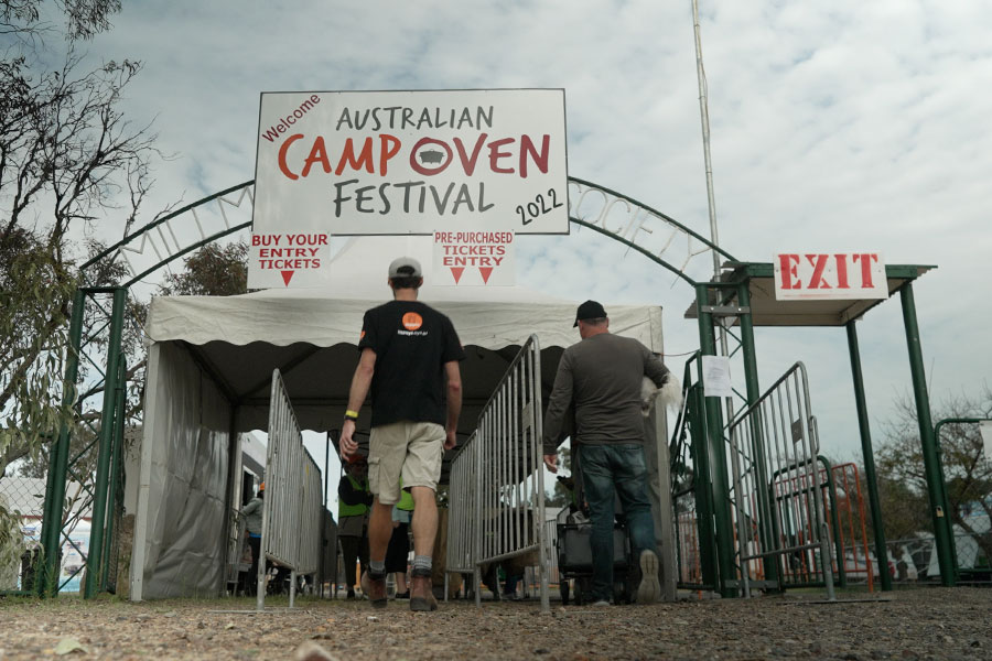 A Snowys staff member is walking through the front entrance of the Australian Camp Oven Festival. wearing a black t-shirt.