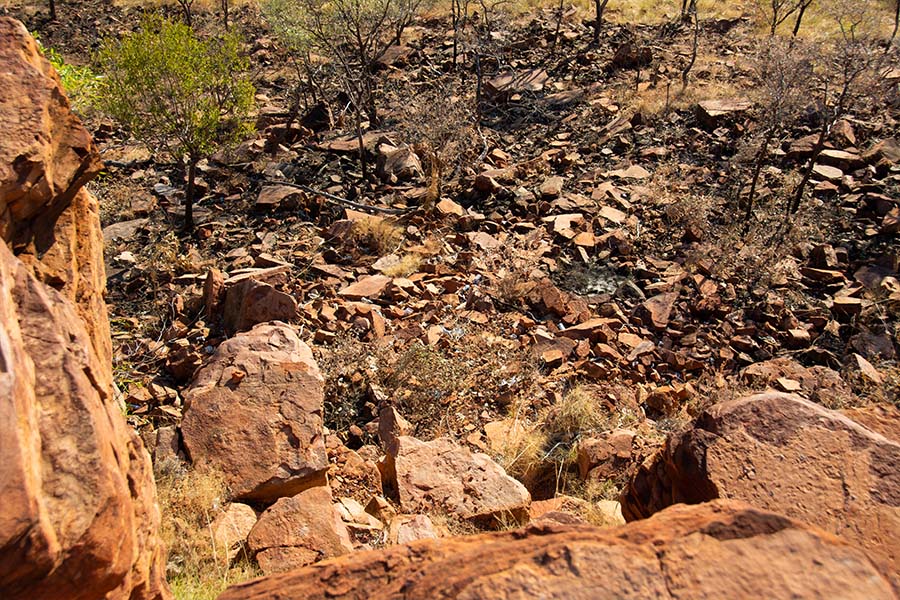 Pieces of rubbish littered across a red rubbly landscape. 