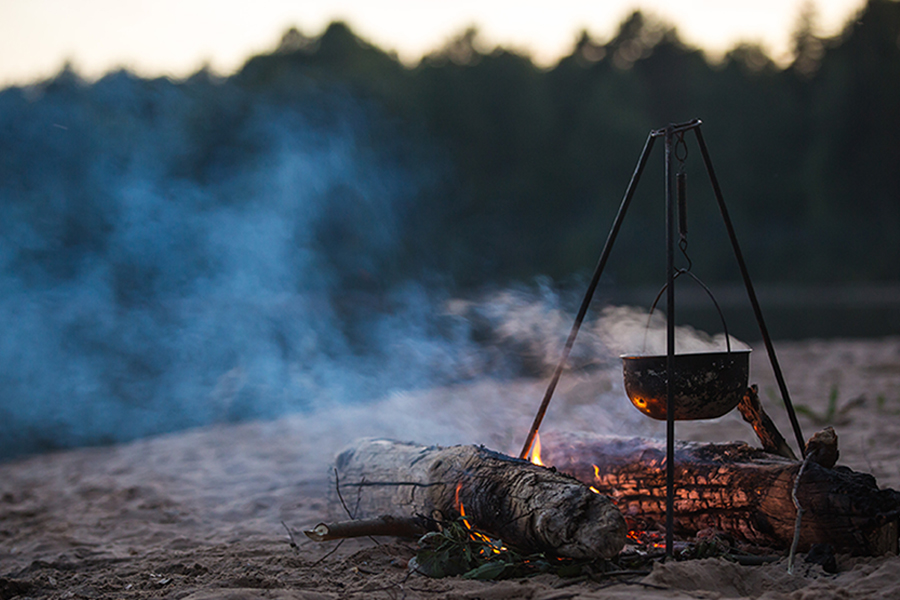 Tune in for an entertaining glimpse into whether our hosts have what it takes to endure the outdoors - completely alone A pot suspended over a campfire.