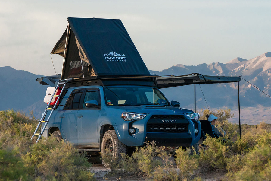 An Inspired Overland rooftop tent set up on a 4WD in the bush.