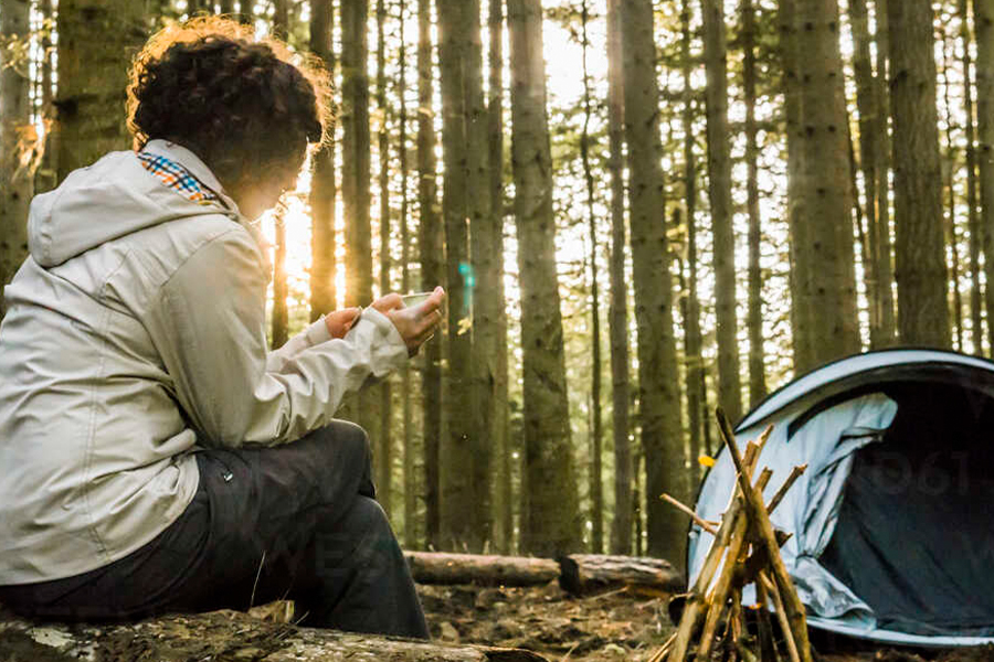 It's AI meets the great outdoors — what could go wrong? A woman on her phone at the campsite.