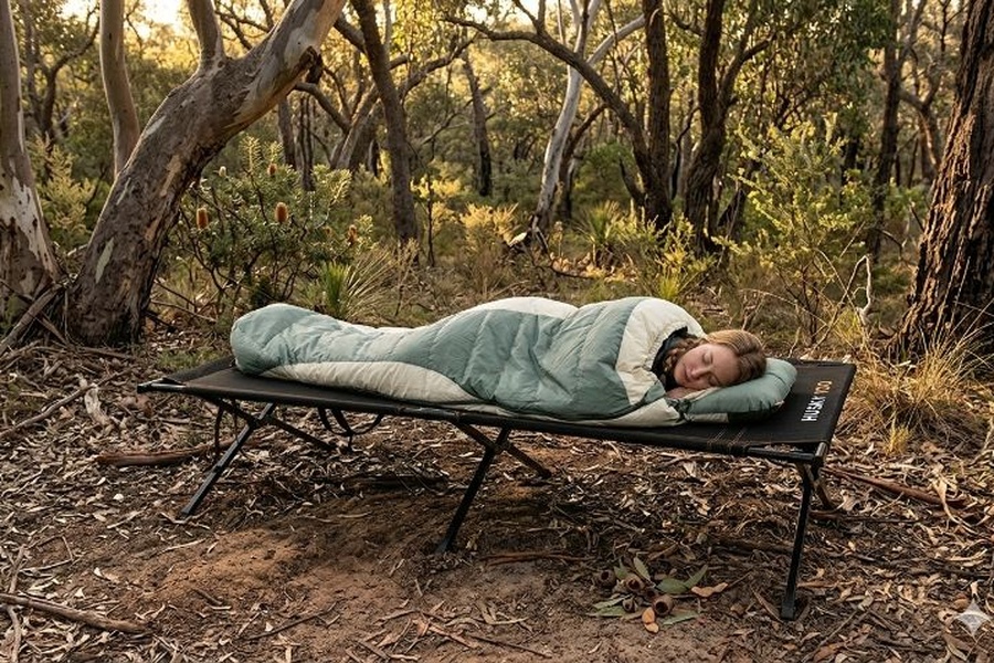 AI generated image of a femal sleepig on a camp stretcher in the Australian bush.